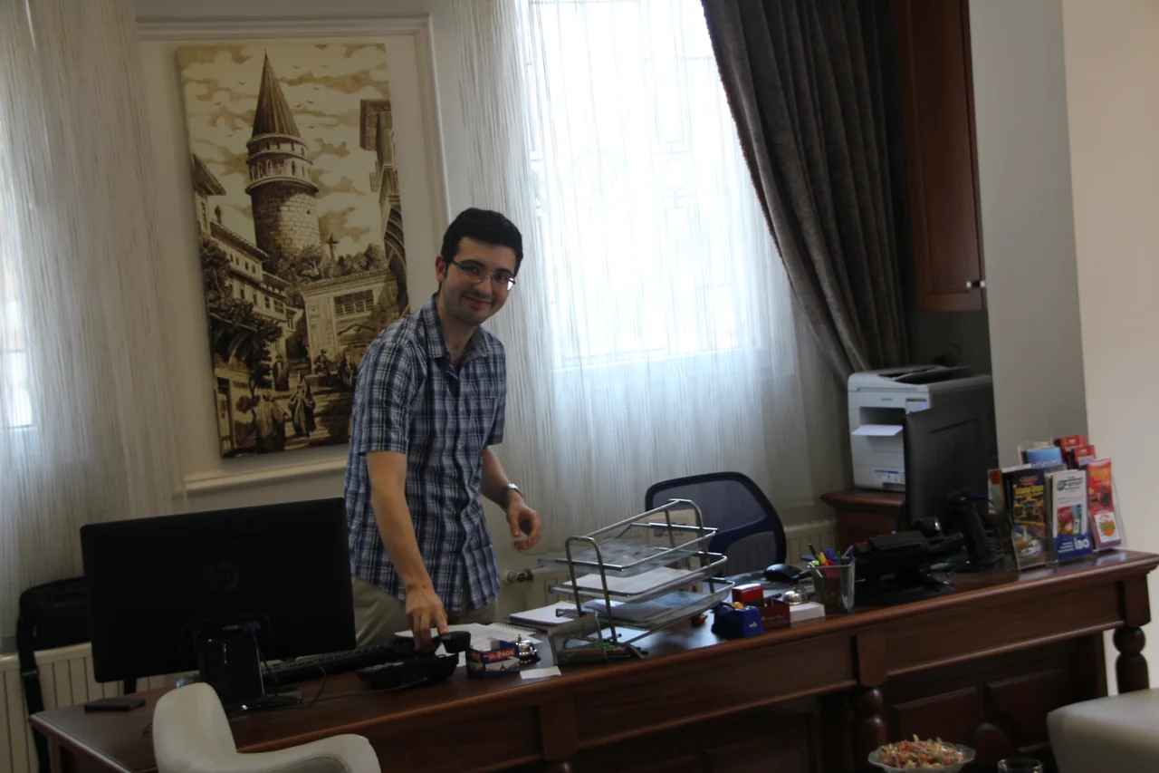 Bir İstanbul otelinin resepsiyonunda, bilgisayarların arkasında duran otel çalışanı.